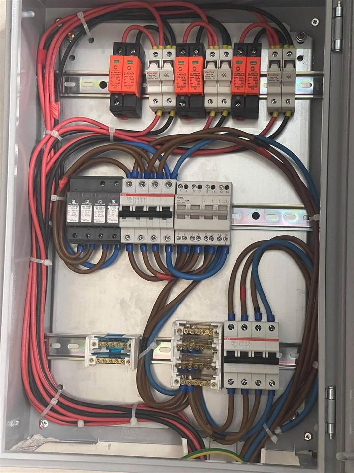 لوحة DC/AC فيها حمايات صواعق وفيوزات وقواطع وأسلاك مرتبة