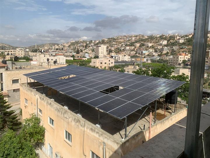ألواح شمسية على هيكل مرفوع فوق سطح بناية